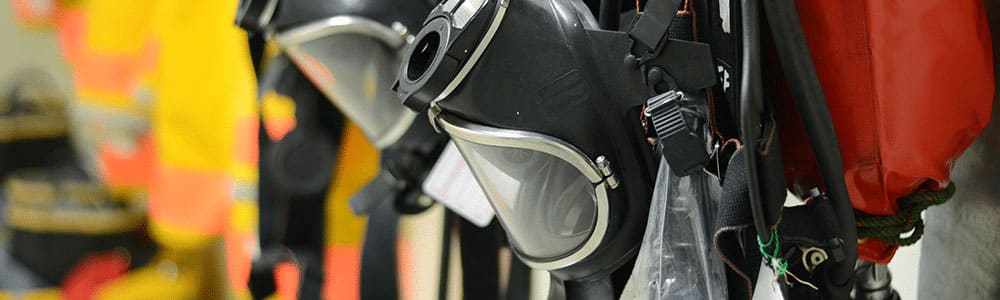 close-up of gas masks hanging on a firehouse wall