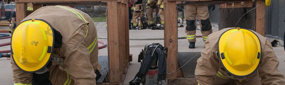 firefighters crawling on their knees during training