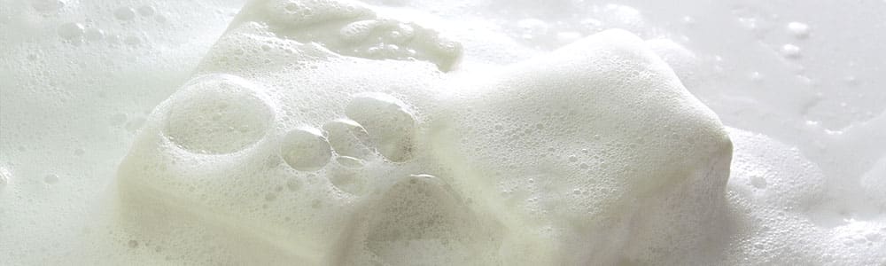 close-up of two bars of soap covered in foam and bubbles