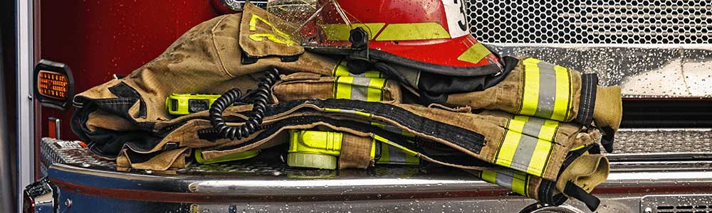 close-up of protective fire gear piled on a firetruck bumper