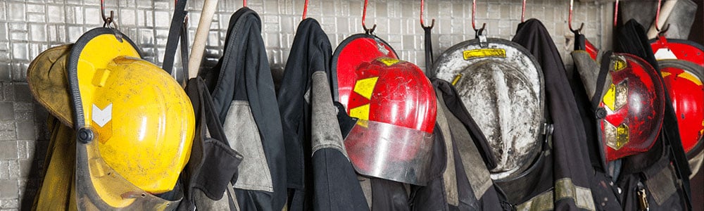 httpsfirefighter's coats and helmets hanging on hooks on the side of a firetruck