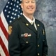 Headshot of Bill Gardner in uniform in front of American flag.