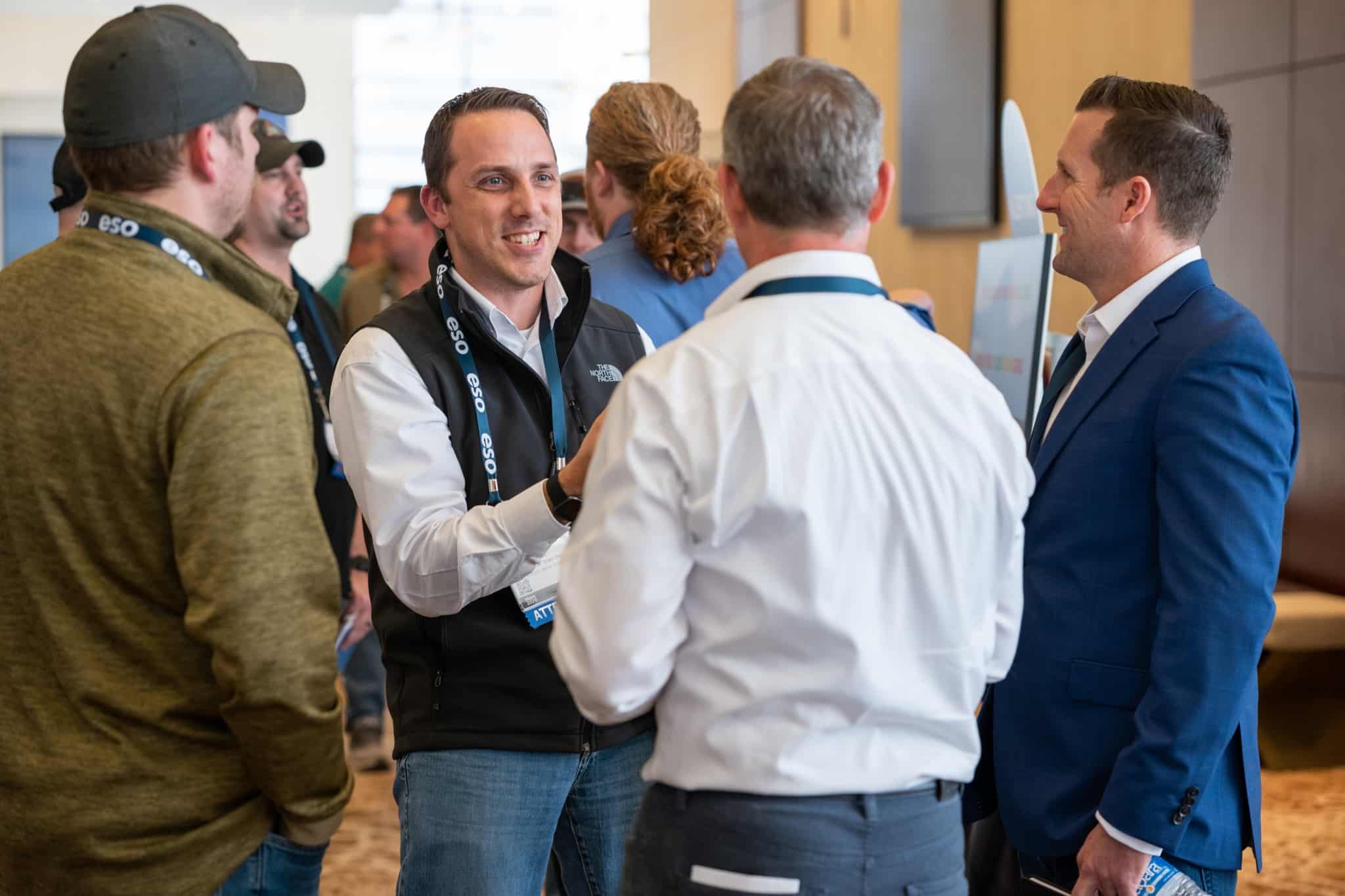 A group of men standing in a small group at an ESO Wave conference.