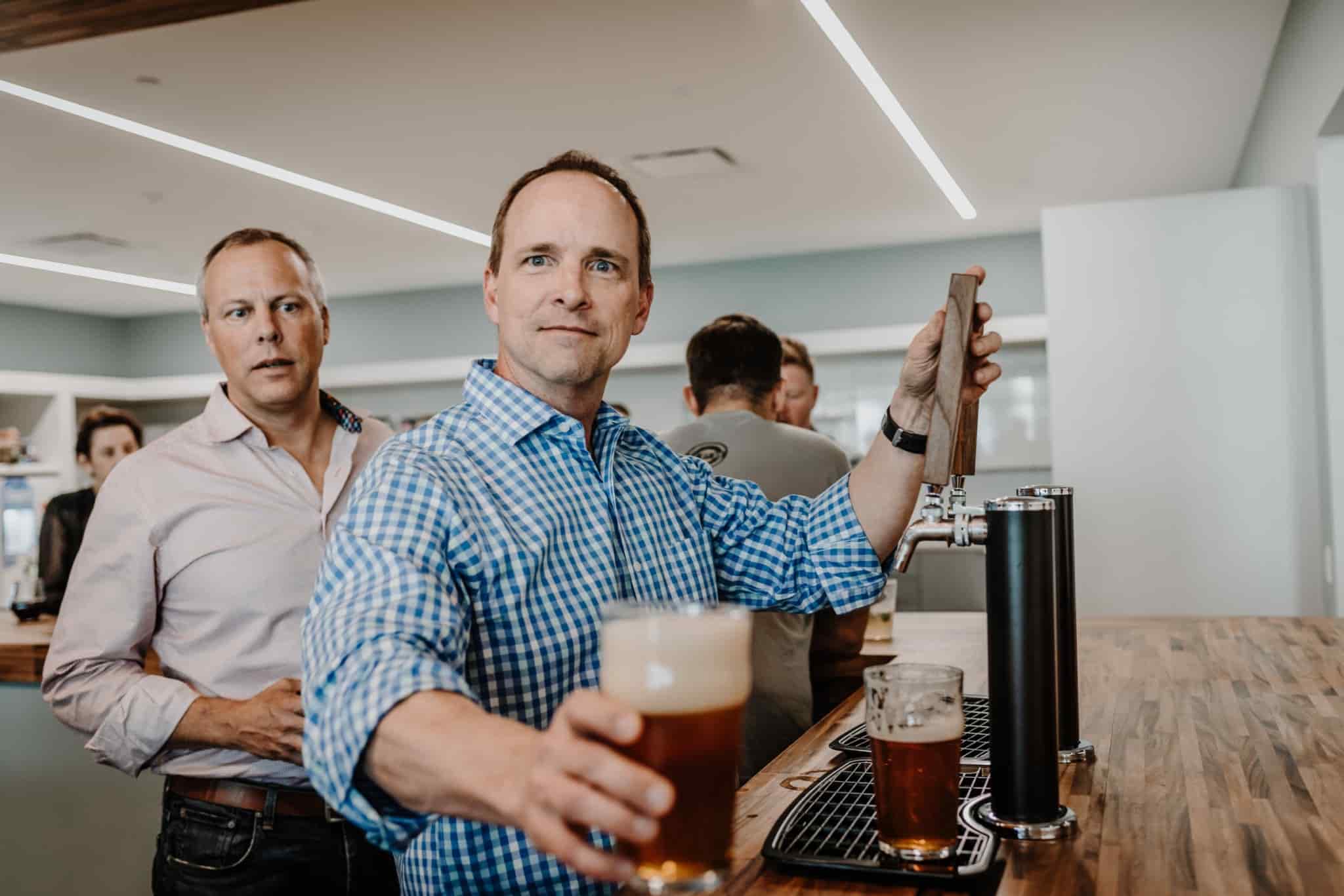 A man pouring beer from a tap at an ESO quarterly happy hour.