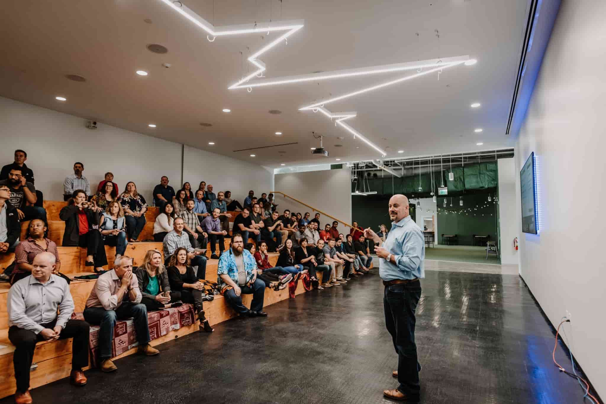 A man speaking to crowd at an ESO quarterly happy hour.